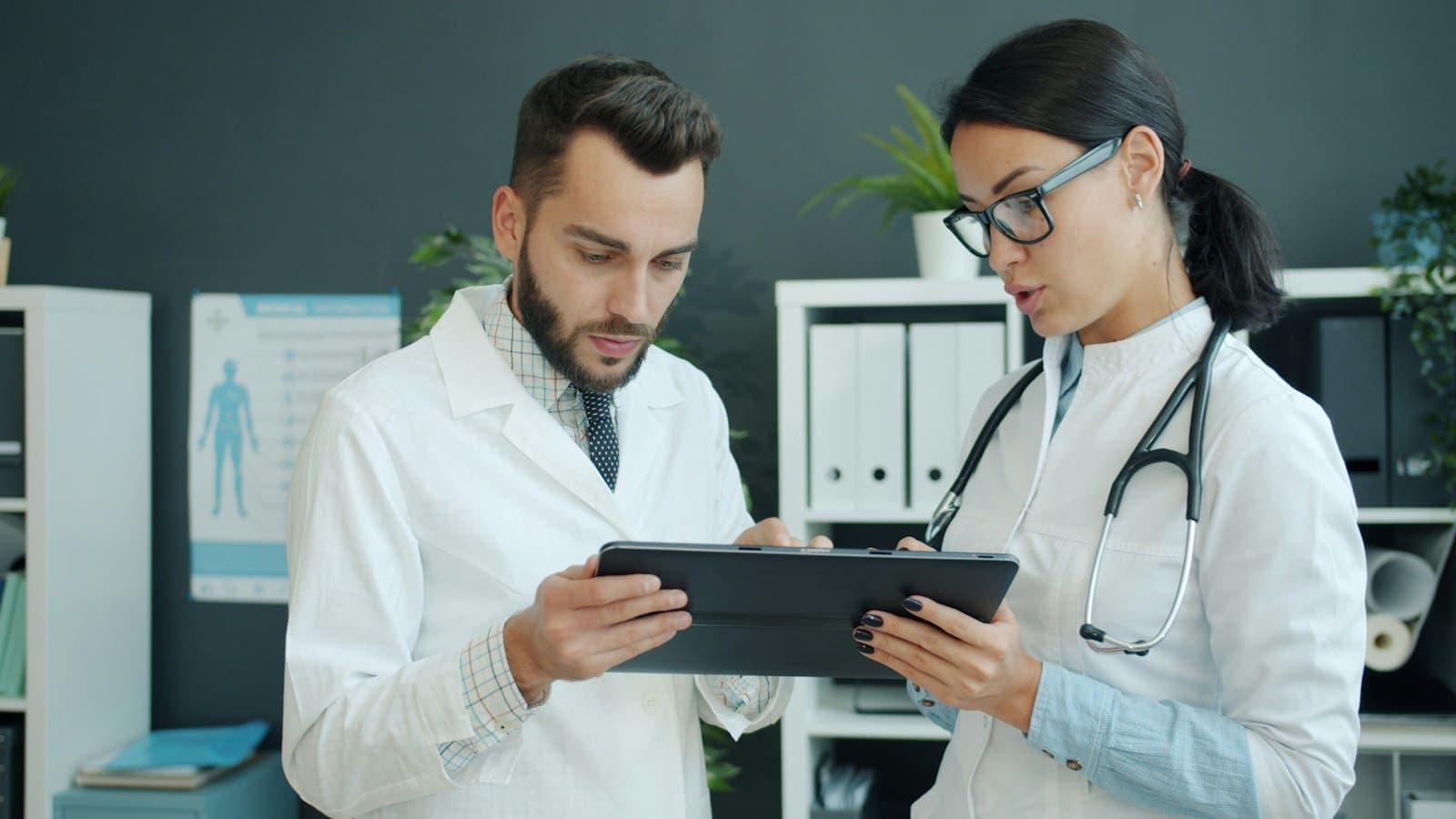 Dois médicos analisando informações em um tablet