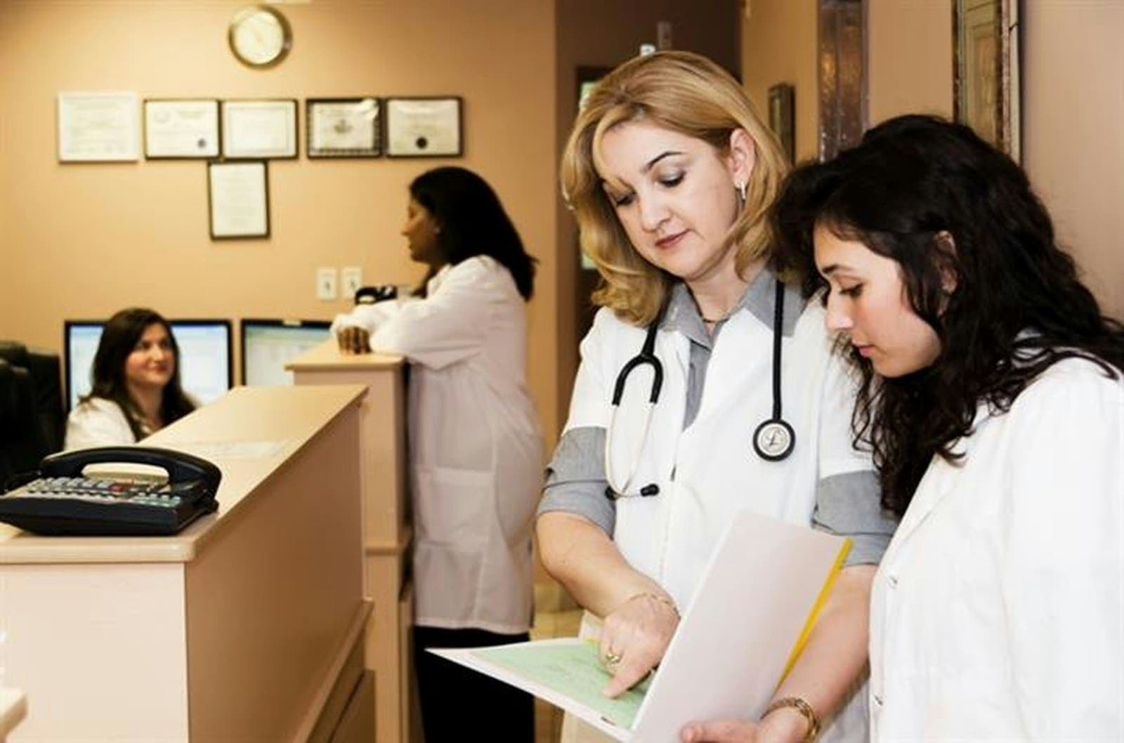 Equipe médica conferindo documentos na recepção de uma clínica